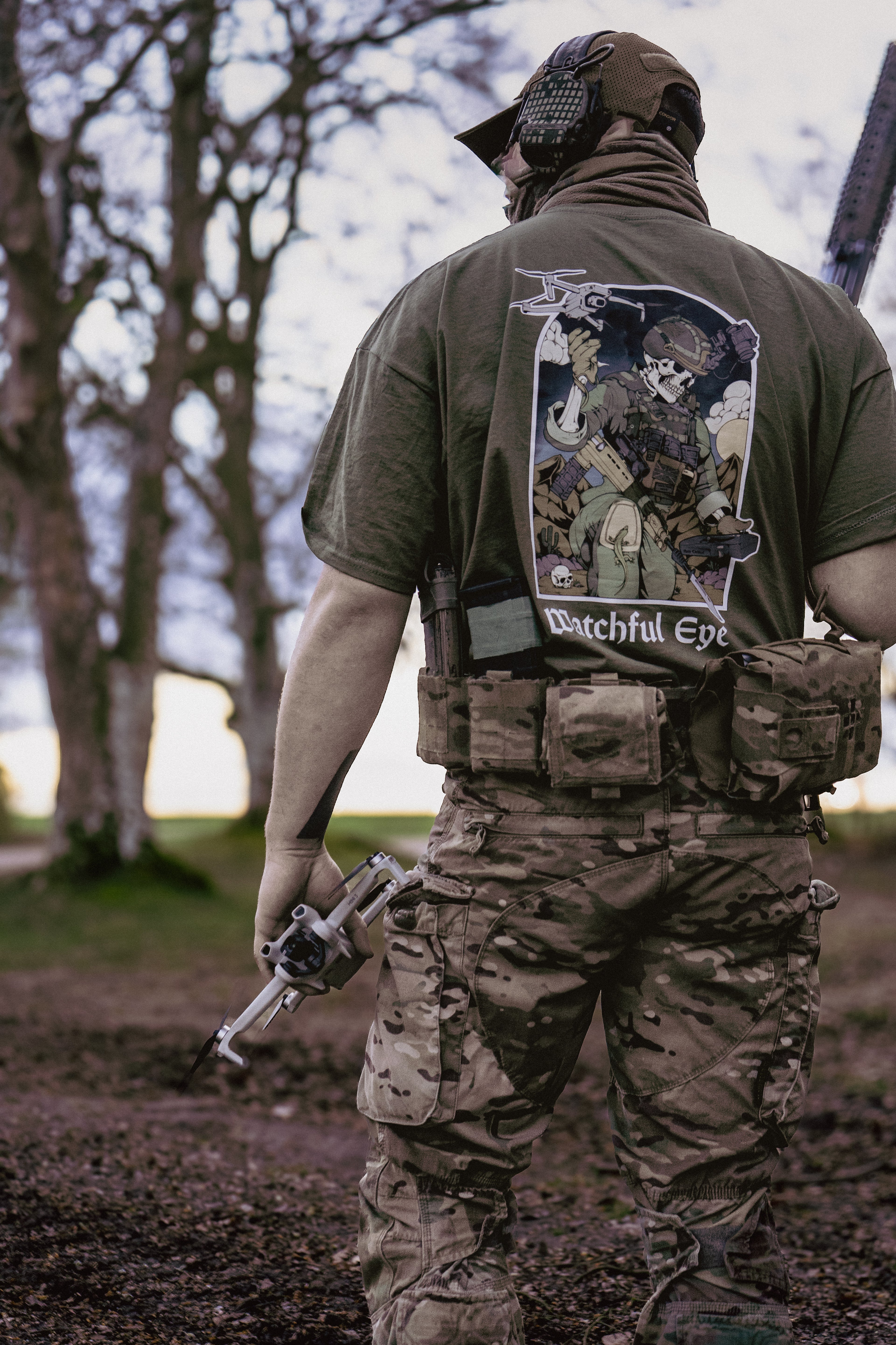 British soldier holding a drone and rifle. Wearing a Mora SUAS drone T-Shirt.